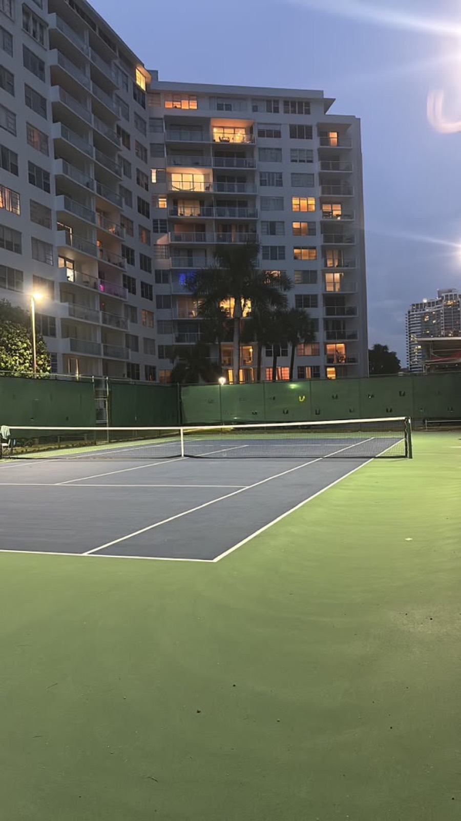 Cancha de tenis iluminada al atardecer en Miami